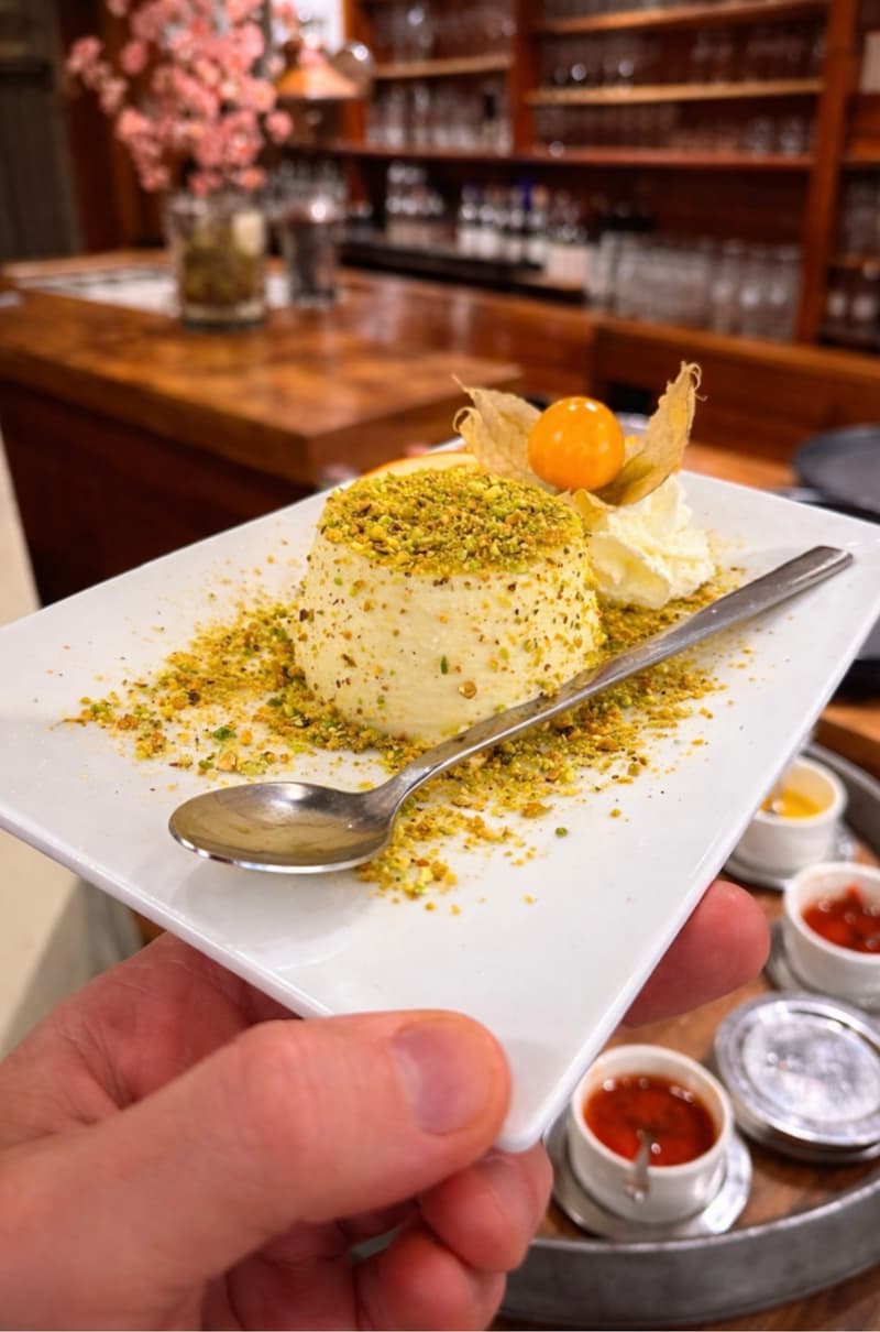 Dessert mit gehackten Pistazien, Sahne und Physalis