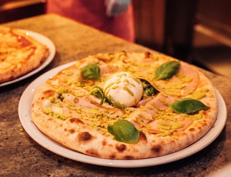 Pizza mit Burrata, Pistazie und Basilikum
